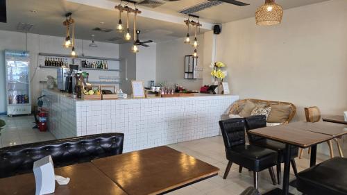 ein Restaurant mit Tischen und Stühlen und eine Bar in der Unterkunft Desa Phuket in Phuket