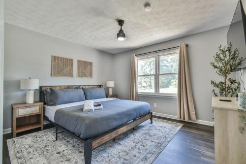 una camera da letto con un letto blu e una finestra di Spacious Home with 3 King Beds, Arcades and 86 inch TV a Snellville