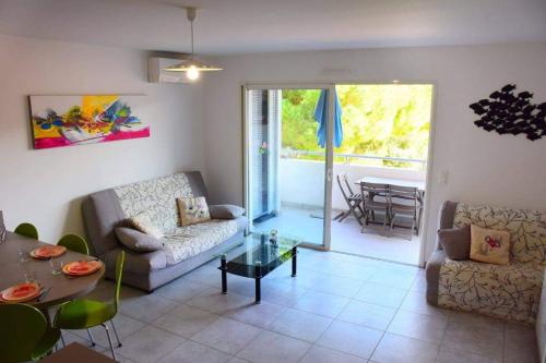 un salon avec un canapé et une table dans l'établissement Appartement l'Orangeraie, à Calvi