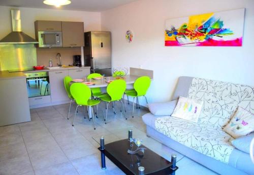 un salon avec un canapé et une table et une cuisine dans l'établissement Appartement l'Orangeraie, à Calvi