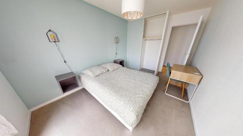 une petite chambre avec un lit et une table dans l'établissement F4 - Rue Jean Le Brozec, au Havre