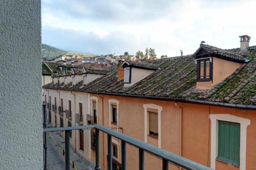 a view of roofs of buildings from a balcony at Hospedium Hotel La Farm in La Granja de San Ildefonso