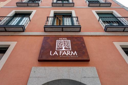 a building with a sign on the side of it at Hospedium Hotel La Farm in La Granja de San Ildefonso