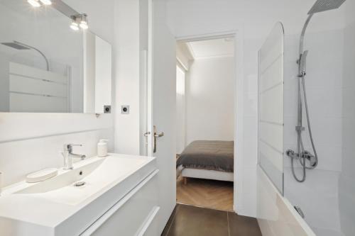 une salle de bain blanche avec un lavabo et une douche dans l'établissement 623 Suite Mont - Superb apartment in Paris, à Paris