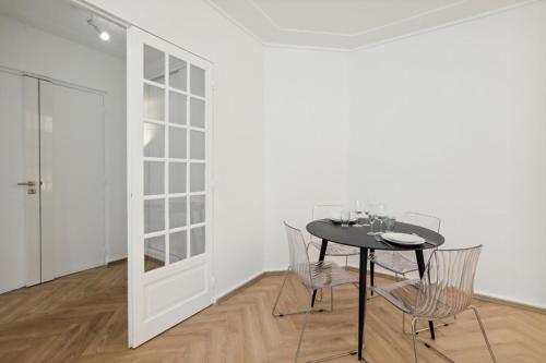 une salle à manger avec une table et des chaises noires dans l'établissement 623 Suite Mont - Superb apartment in Paris, à Paris