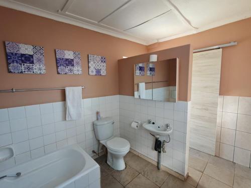 Un baño con inodoro, bañera y lavabo. en Lullaby Leaves Guesthouse, en Lichtenburg