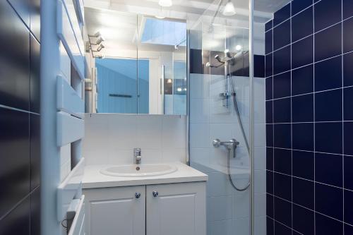 une salle de bain avec un lavabo et une douche avec un miroir dans l'établissement Le Clos des Sternes, à La Flotte