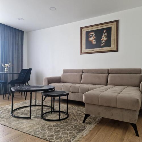 a living room with a couch and two tables at Nauji centro apartamentai in Panevėžys