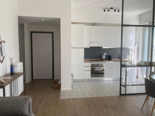 a living room with white cabinets and a kitchen at Verde Salvia Home - Free park in Tavernerio