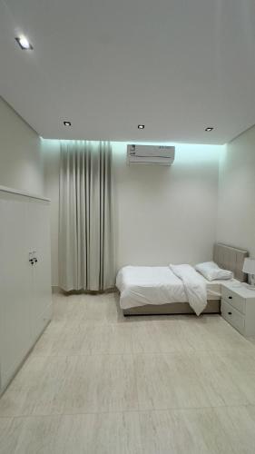 ein weißes Schlafzimmer mit einem Bett und einem Fenster in der Unterkunft Luxury Apartment for Rent Summer in Quai