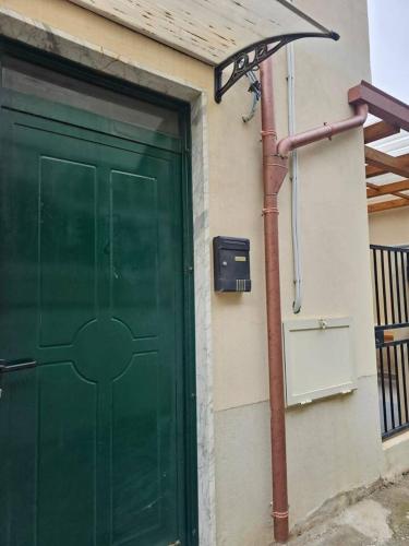 a green door of a house with a metal pole at Tra Mare e Terra Reggio Calabria in Lazzaro