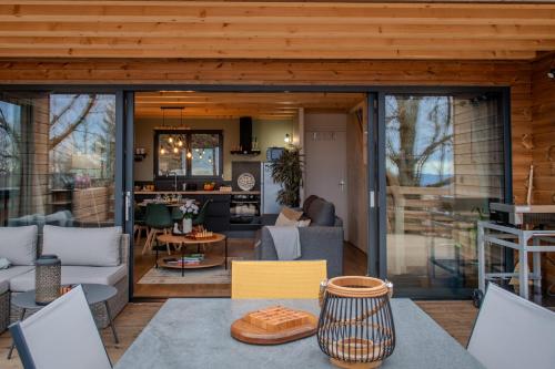 a living room and kitchen with sliding glass doors at Les Gites du O' Forêt-Gîte O'rizon avec bain nordique et magnifique vue sur la plaine du forez in Verrières-en-Forez