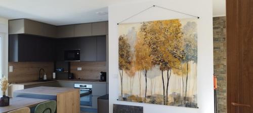une cuisine avec une peinture d'arbres sur le mur dans l'établissement Villa Viktoriia, à San-Nicolao