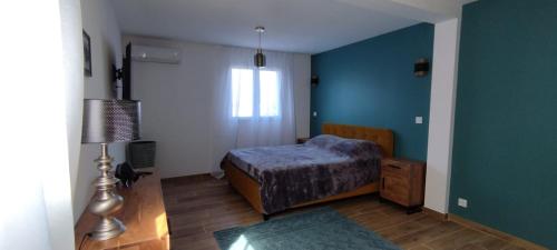 une chambre avec un lit et un mur bleu dans l'établissement Villa Viktoriia, à San-Nicolao