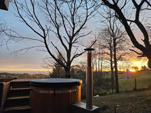 a trash can in a park with a sunset in the background at Les Gites du O' Forêt-Gîte O'rizon avec bain nordique et magnifique vue sur la plaine du forez in Verrières-en-Forez