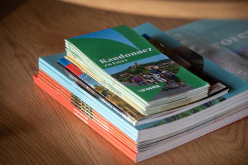 a stack of books sitting on top of a table at Les Gites du O' Forêt-Gîte O'rizon avec bain nordique et magnifique vue sur la plaine du forez in Verrières-en-Forez