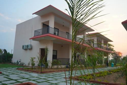 a house with a palm tree in front of it at Sundervan Vilas Ranthambore in Khilchipur