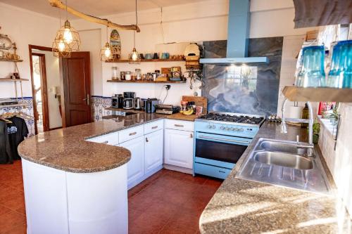 a kitchen with white cabinets and a blue stove top oven at Santa Cruz Surf House by Stoke Travel in A dos Cunhados