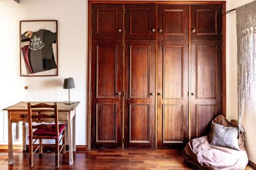 a room with a table and a wooden cabinet at Santa Cruz Surf House by Stoke Travel in A dos Cunhados