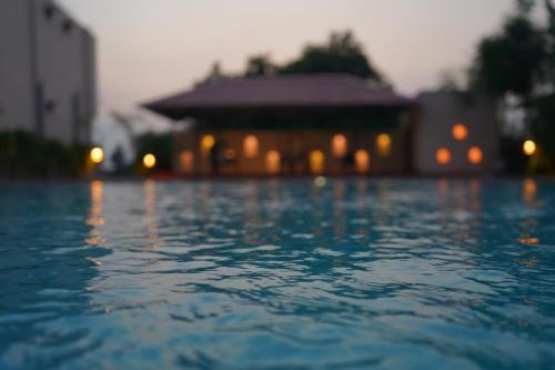 a pool of water with a building in the background at Sundervan Vilas Ranthambore in Khilchipur