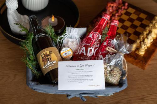 a basket filled with bottles of wine and food at Les Gites du O' Forêt-Gîte O'rizon avec bain nordique et magnifique vue sur la plaine du forez in Verrières-en-Forez