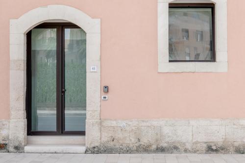 an entrance to a pink building with a glass door at Eos - Elegants Apartments & Suites in Siracusa