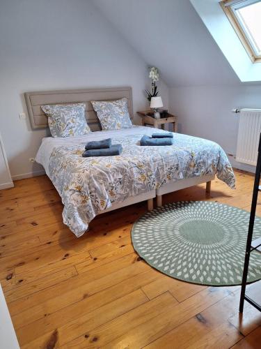 une chambre avec un lit et un parquet dans l'établissement Ô Charme de St Ô, à Saint-Omer