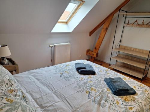 a bedroom with a bed with two towels on it at Ô Charme de St Ô in Saint-Omer