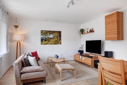 a living room with a couch and a tv at Ferienwohnung am Schwellenweiher in Feldberg