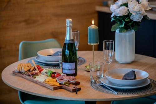 a table with a bottle of wine and a plate of food at Les Gites du O' Forêt-Gîte O'rizon avec bain nordique et magnifique vue sur la plaine du forez in Verrières-en-Forez
