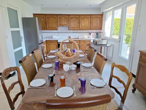 une cuisine avec une table et des assiettes ainsi qu'un panier dans l'établissement Ô Charme de St Ô, à Saint-Omer
