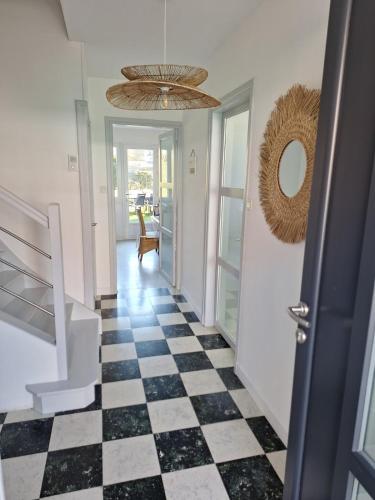 - un couloir avec un sol en damier noir et blanc dans l'établissement Ô Charme de St Ô, à Saint-Omer