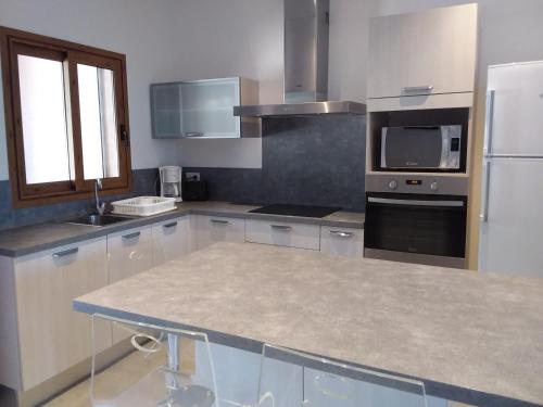 une cuisine avec des appareils en acier inoxydable et un comptoir dans l'établissement jolie location, à Porto-Vecchio