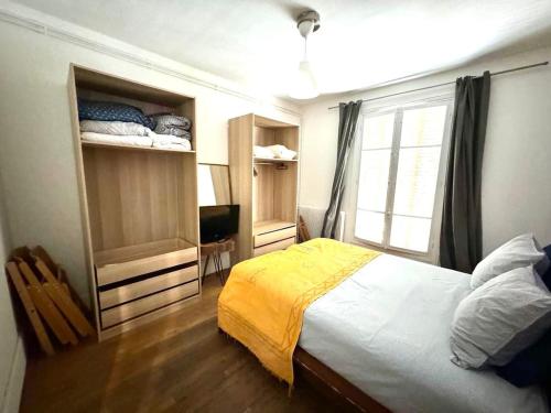 une chambre avec un grand lit et une fenêtre dans l'établissement Grand F2 Roland Garros Paris Auteuil, à Boulogne-Billancourt