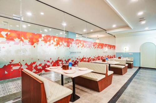 a restaurant with tables and chairs and a mural at Saltstayz Premier - Arjun Marg in Gurgaon