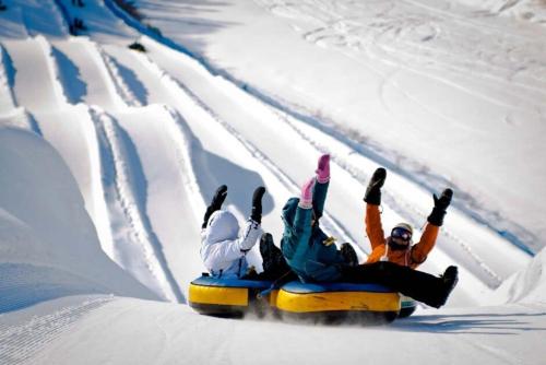 three people are riding on a sled in the snow at Quebec city Downtown River Sidewalk 2 Free Parking in Quebec City