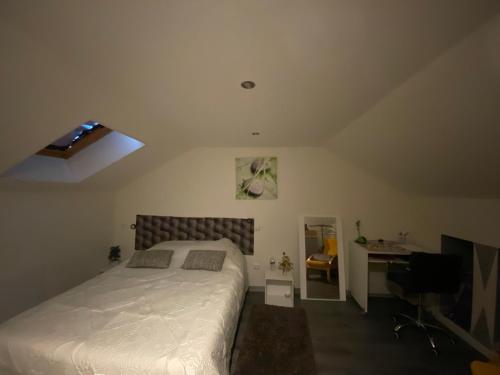 une chambre avec un grand lit et un bureau dans l'établissement Gîte détente, à Brévonnes