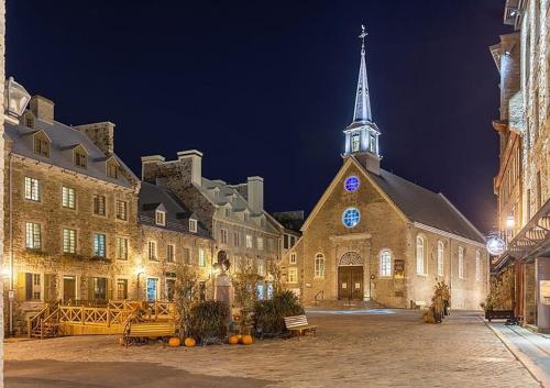 a large building with a church with a steeple at night at Quebec city Downtown River Sidewalk 2 Free Parking in Quebec City