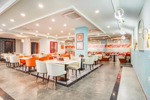 a dining room with tables and chairs in a restaurant at Saltstayz Premier - Arjun Marg in Gurgaon
