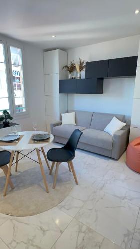un salon avec un canapé et une table dans l'établissement Palais du Soleil vacances dans un immeuble art déco, à Antibes