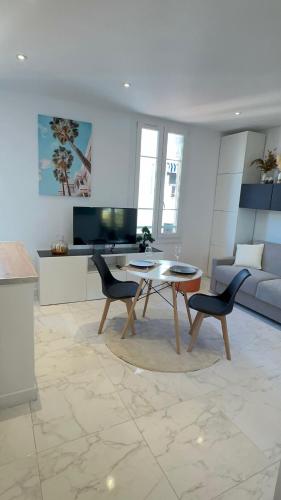 un salon avec une table et deux chaises dans l'établissement Palais du Soleil vacances dans un immeuble art déco, à Antibes