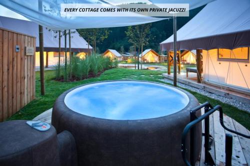 een jacuzzi in de tuin met een tent bij Herbal Glamping Resort Ljubno in Ljubno
