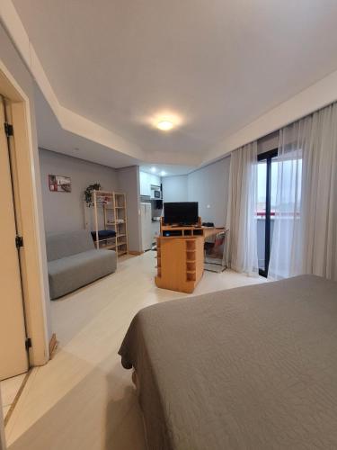 a bedroom with a bed and a couch and a television at Hotel Bien Sena Madureira Ibirapuera Com Garagem 1101 in Sao Paulo