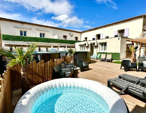 a patio with a swimming pool and a building at Les Appartement du Mas - RUBIS in Aigues-Mortes