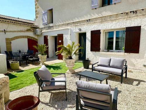 a patio with chairs and a table and a building at Les Appartement du Mas - RUBIS in Aigues-Mortes