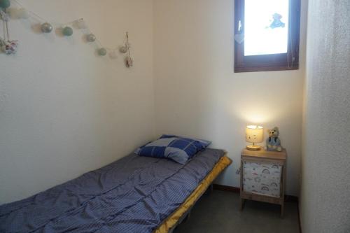 une petite chambre avec un lit et une fenêtre dans l'établissement Barcarelles au Barcarès Plage Piscine 5 personnes, au Barcarès