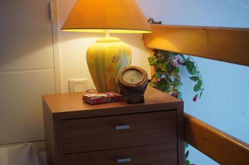 une table avec une lampe et une horloge sur celle-ci dans l'établissement Barcarelles au Barcarès Plage Piscine 5 personnes, au Barcarès