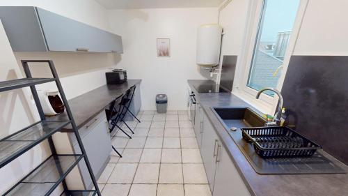 une petite cuisine avec un évier et une fenêtre dans l'établissement Magnifique studio Franklin, au Havre
