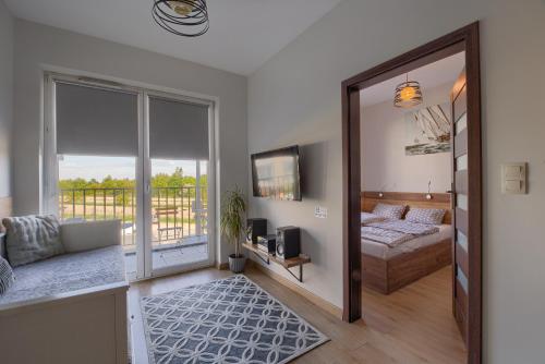 a living room with a bed and a sliding glass door at Apartamenty Galicja Zator in Zator