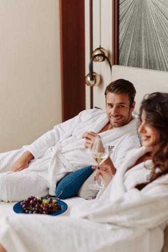 a man and a woman laying in a bed with a plate of food at Signature Villa in Budva
